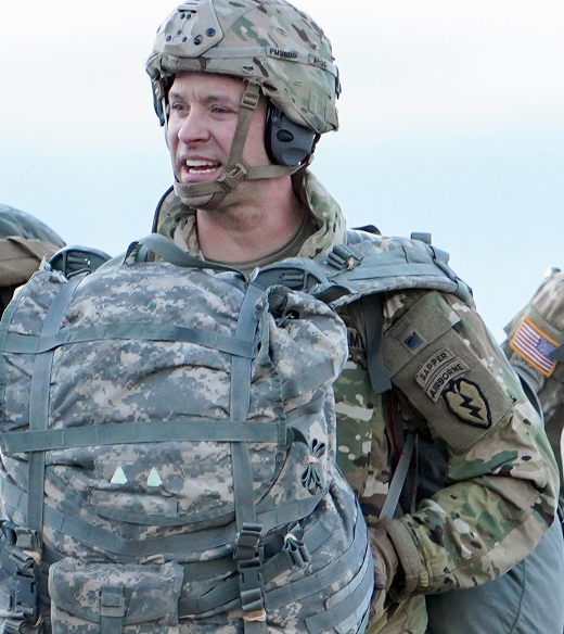 A United States soldier holding his pack against his chest.